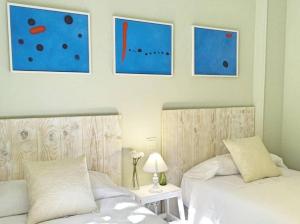 1 Schlafzimmer mit 2 Betten und Wandmalereien in der Unterkunft Beyourself by SevillaLuxurySuites in Sevilla