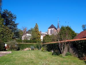 Blick auf einen Garten mit einem Haus im Hintergrund in der Unterkunft La Maison d'hotes de Toucy in Toucy