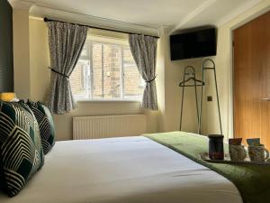 a bedroom with a bed with a television and a window at Red Lion in Bakewell