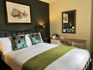a bedroom with a large bed and a mirror at Red Lion in Bakewell