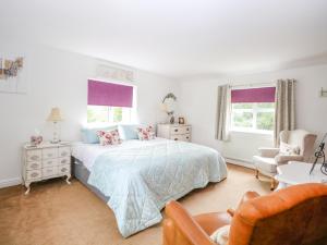 1 dormitorio blanco con 1 cama y 1 silla en Willow Cottage en Norwich