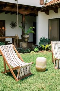 een paar stoelen en een steen in een tuin bij Casi Casa in Antigua Guatemala