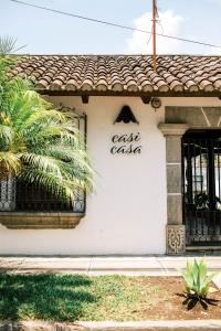 een wit gebouw met een bord dat salsa van de cast leest bij Casi Casa in Antigua Guatemala