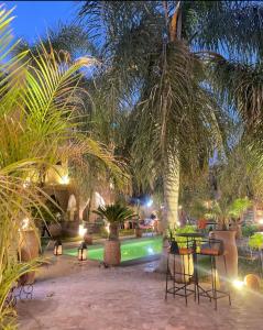a patio with a table and chairs and palm trees at Dar Riad Niama in Taroudant