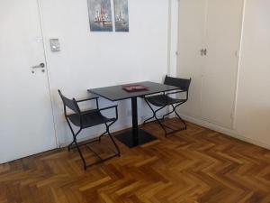 a black table and two chairs in a room at Departamento en Recoleta muy luminoso Piso 10 in Buenos Aires