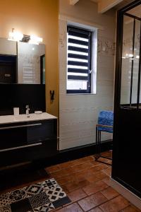 baño con lavabo y ventana en Gite Les Volets Rouges, en Andres