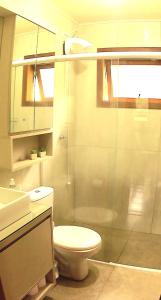 a bathroom with a toilet and a glass shower at Cabana das Montanhas in Caxias do Sul