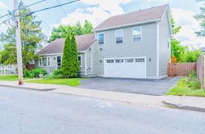 une maison grise avec un garage blanc dans l'établissement Entire Hi-Tech House with 4 Bedrooms, Fitness Room, 10 mins to Providence, à Cranston