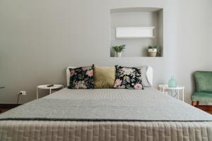 1 dormitorio con 1 cama y 1 silla verde en AURA, en Terlizzi