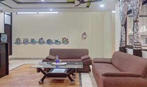 Sala de estar con 2 sofás y mesa de centro en Itsy By Treebo - Albie Stay Inn, en Manī Mājra