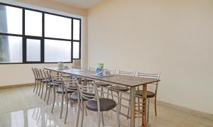 a dining room with a wooden table and chairs at Itsy By Treebo - Albie Stay Inn in Manī Mājra