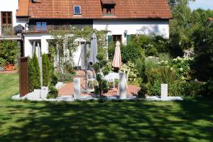 un jardín con sombrilla, mesa y sillas en Ferienwohnung Birkenried en Reisensburg