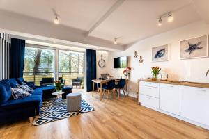 un salon avec un canapé bleu et une table dans l'établissement Apartament 21B Niebieskie Apartamenty z basenem krytym, odkrytym, salą zabaw, animacjami, à Poddąbie