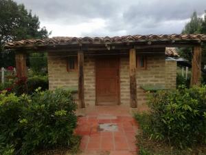 una entrada de madera a una casa con puerta de madera en Estancia El Sol en Sogamoso