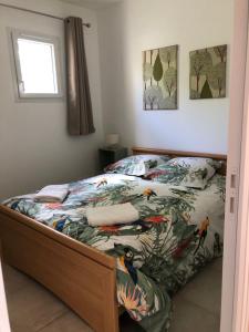 - une chambre avec un lit et une couette colorée dans l'établissement La Poupe, F3 avec terrasse à 60m de la plage, à Saint-Côme-de-Fresné