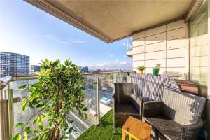 ロンドンにあるTwo Bedroom Apartment - London ExCeL Staysの市街の景色を望むバルコニー(椅子2脚付)