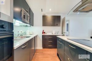 ロンドンにあるTwo Bedroom Apartment - London ExCeL Staysのキッチン(青と白のキャビネット、シンク付)