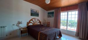 a bedroom with a bed and a large window at Casa Angelina in O Grove