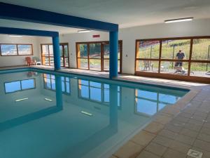 una piscina con columnas azules en un edificio en Appt 4 a 6 pers aux pieds des pistes Les terrasses du soleil d or résidence avec piscine, en Les Orres