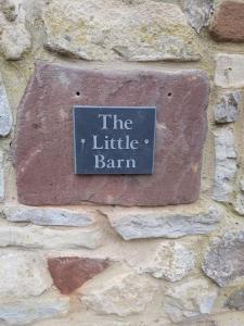 a sign on the side of a stone wall at Hidden gem on the edge of the Cotswolds in Charfield