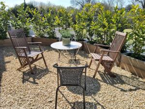 2 sillas y una mesa en el patio en Hidden gem on the edge of the Cotswolds en Charfield