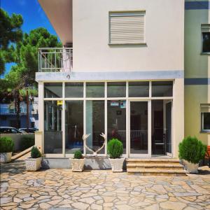 a building with large glass doors and potted plants at Hotel Gonaj in Velipojë