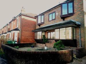 una casa de ladrillo con una pared de ladrillo delante de ella en The Retreat, a Luxury Riverside Cottage & garden en Southampton