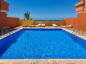 basen z niebieską wodą przed budynkiem w obiekcie Panorama Ocean View Gigantes w mieście Santiago del Teide