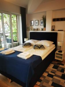 un grand lit avec deux serviettes dessus dans l'établissement Apartament 21B Niebieskie Apartamenty z basenem krytym, odkrytym, salą zabaw, animacjami, à Poddąbie