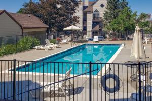 a swimming pool in front of a house at Charming Greenwood Village Condo with Patio! in Greenwood Village