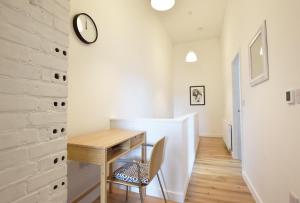 a dining room with a table and a clock on a wall at Modern Apartment In The Centre of Teignmouth in Teignmouth