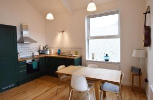 a kitchen with a wooden table and a window at Modern Apartment In The Centre of Teignmouth in Teignmouth
