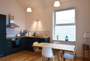 a kitchen with a wooden table and a window at Modern Apartment In The Centre of Teignmouth in Teignmouth