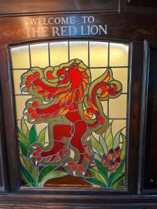 una vidriera con un dragón rojo. en Red Lion, en Bakewell