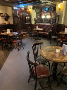 a restaurant with tables and chairs and a couch at Red Lion in Bakewell