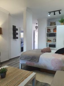a white bedroom with a bed and a table at Playa del Ingles Estudio LOS MOLINOS 205 in Maspalomas