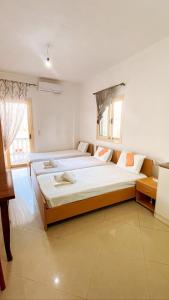 a large bedroom with two beds and a window at Ksamildream in Ksamil