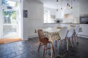 a kitchen with a table and chairs in a room at Ty Golau - 3 Bed Holiday Home - Pembroke in Pembroke