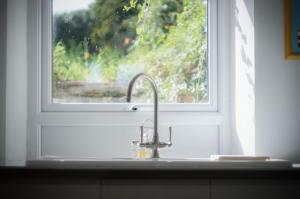 eine Küchenspüle vor einem Fenster in der Unterkunft Ty Golau - 3 Bed Holiday Home - Pembroke in Pembroke + 29 Fotos