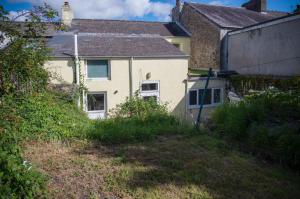 a white house with a yard in front of it at Ty Golau - 3 Bed Holiday Home - Pembroke in Pembroke