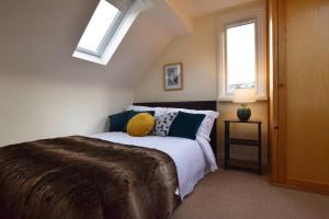 1 dormitorio con 1 cama y 2 ventanas en St Keyne - A Hidden Gem Nestled in Shaldon en Shaldon