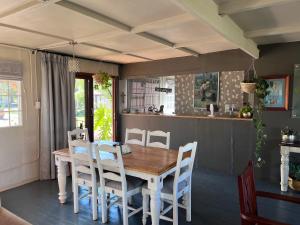 a dining room with a wooden table and chairs at Three Thymes Inn in Tierpoort