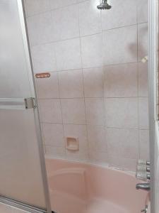 a shower with a glass door next to a tub at Amplio, bonito, clásico Departamento en San Isidro in Lima