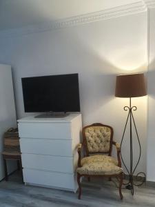 a room with a tv and a chair and a lamp at Playa del Ingles Estudio LOS MOLINOS 205 in Maspalomas