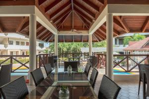 - un coin repas extérieur avec une table et des chaises en verre dans l'établissement Hotel Silvestre, à La Romana