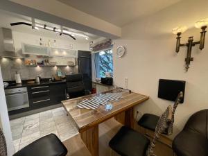 cocina y sala de estar con mesa de madera en Apartment am Roten Tor en Augsburg