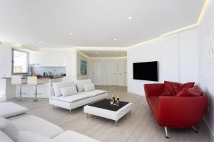 a living room with a couch and a red chair at Deluxe Apartment in Costa Adeje in Adeje