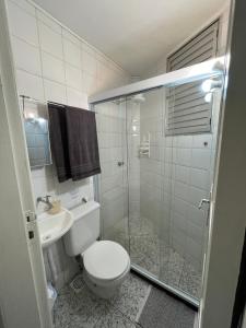 a bathroom with a shower and a toilet and a sink at KITNET ACONCHEGANTE A 3 MINUTOS DA PRAIA in Guarapari