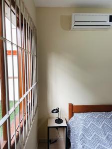 ein Schlafzimmer mit einem Bett und einer Lampe auf einem Tisch in der Unterkunft Casa em Bombas in Bombinhas