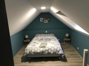 a bedroom with a bed with a laptop on it at Gîte spa sauna piscine in Aubin-Saint-Vaast